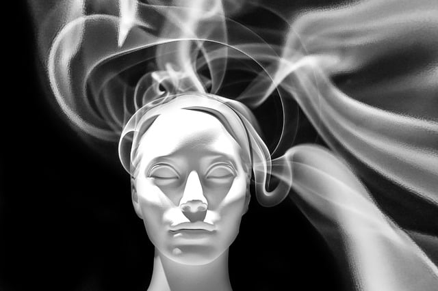 black and white image of ghostly woman's face with smoke flowing out like hair from her head